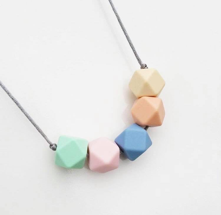 A silicone teething necklace in pretty summer pastel shades by Mama Knows at Our Kid