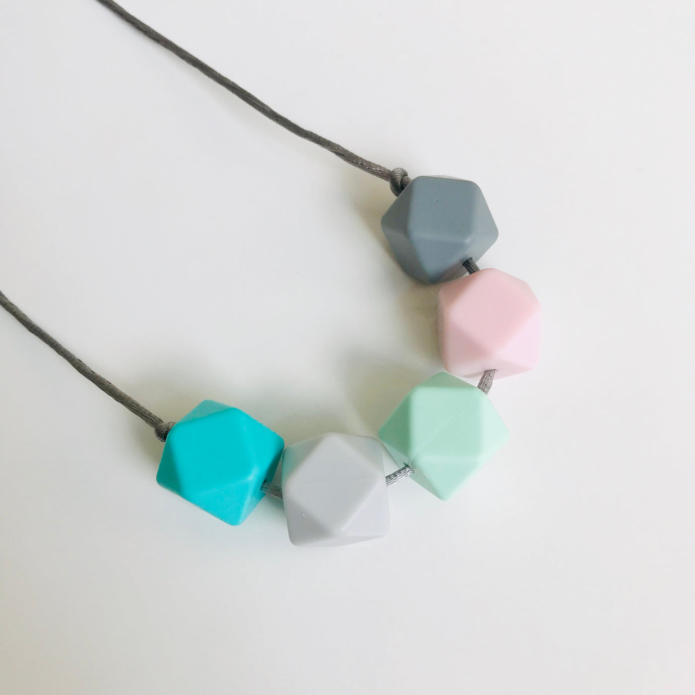 A silicone teething necklace in pretty pastel shades by Mama Knows at Our Kid